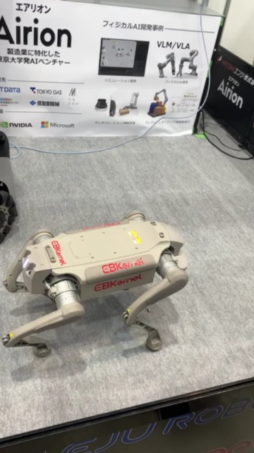 Airionブースで展示された四足歩行ロボット。背後にVLM・VLAなどのフィジカルAI開発事例を紹介するパネル